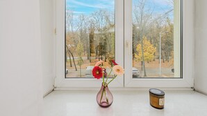 A window with a vase of flowers and a candle on the windowsill. - ShortStayPoland Szara B170 (Warsaw)