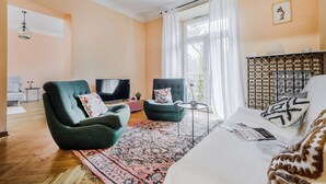 A living room with a sofa, armchair, TV, and a patterned rug. - ShortStayPoland Szara B170 (Warsaw)