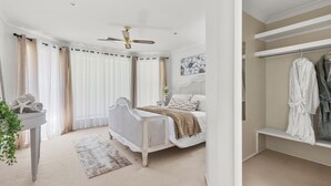 A bedroom with a bed, bedside table, and a ceiling fan. - Room in Studio - Nice Studio on Jasmine (Bomaderry)