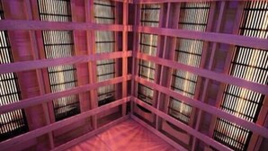Una habitación con varios ventanales y suelo de madera.