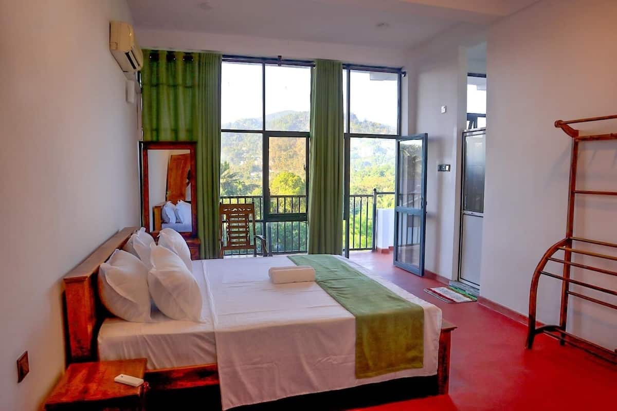 Une chambre d’hôtel avec un lit, une chaise, un balcon avec vue et une télévision.