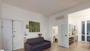 A modern apartment with a living room, kitchenette, and a dining area. - Charlotte apartment wheels (Firenze)