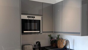 Eine kompakte Küche mit Einbauofen, Toaster und Kaffeemaschine.
