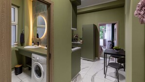 A compact bathroom with a washing machine, a sink, and a mirror. - Serene 1BR Apartment in University Square (Bucharest)