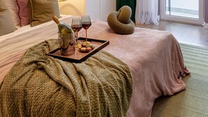 A bedroom with a bed, a bedside table with a lamp, a window with curtains, and a view of greenery outside. - Serene 1BR Apartment in University Square (Bucharest)