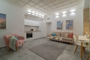 Ein modernes Wohnzimmer mit Sofa, Couchtisch und Essbereich.