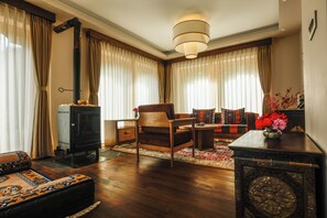 Una sala de estar acogedora con chimenea, un sofá, una mesa de centro y una alfombra.
