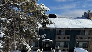 A snow-covered pathway leading to a building with a dark facade and multiple windows. - 2-bedroom 2 bath condo in Winter Park, magnificent views, hot tub, close to town (Winter Park)