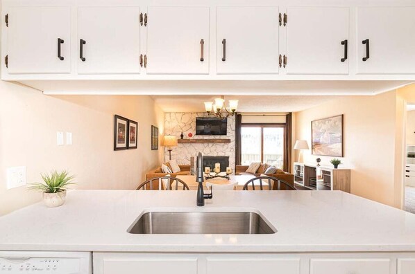 Kitchen features a large island with a dishwasher and a stainless steel sink.