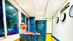 A hotel reception area with a reception desk, a clock, and a sign indicating check-out times. - Hotel BKC Fortune  (Mumbai)