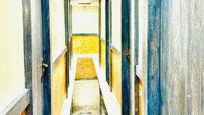 A long, narrow hallway with doors on both sides, a marble floor, and a yellow and white wall at the end. - Hotel BKC Fortune  (Mumbai)