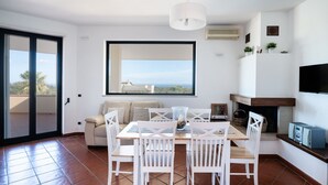 Una cocina moderna con zona de comedor, ventanas amplias y chimenea.