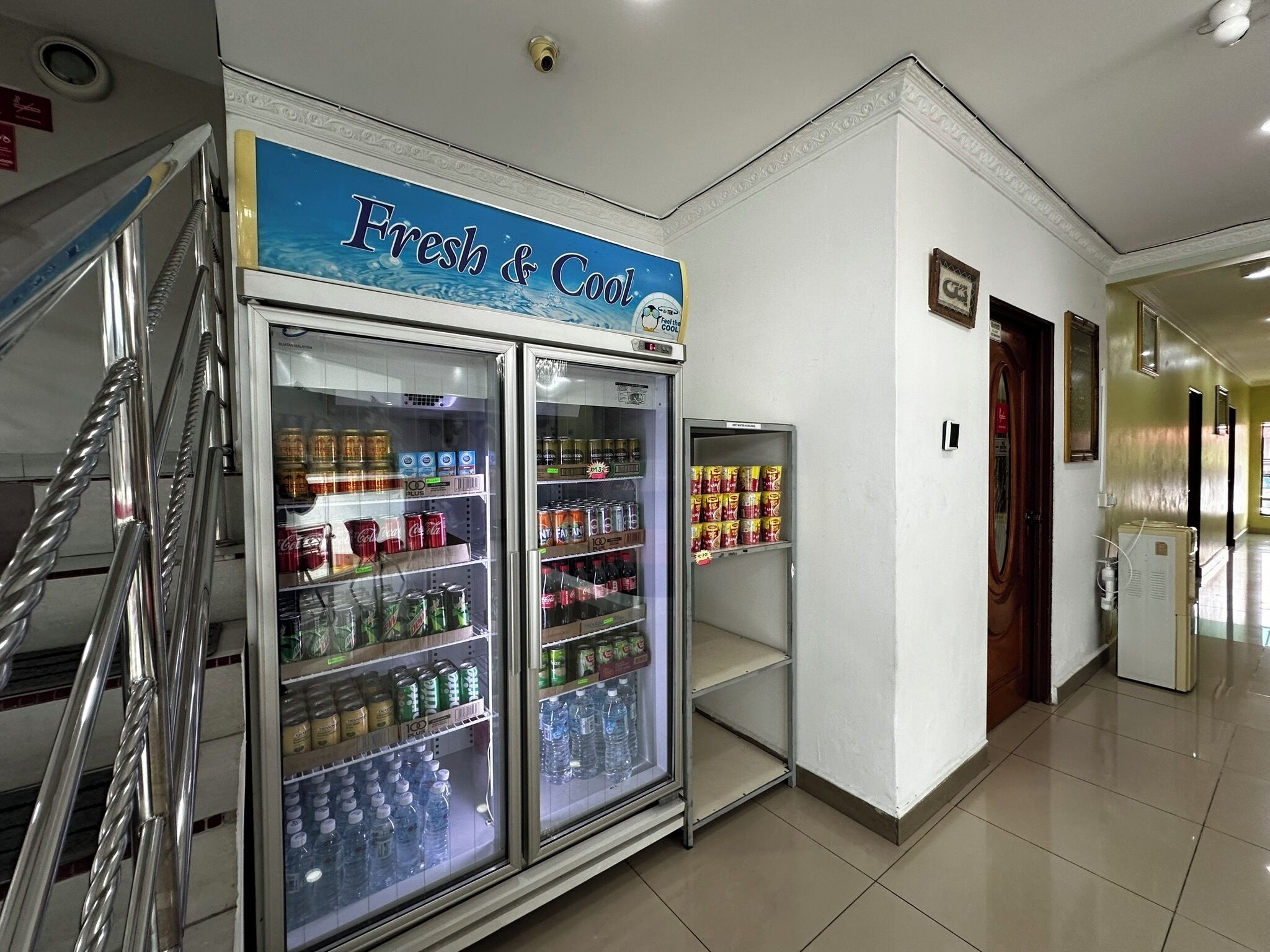 A hallway with a vending machine labeled "Fresh & Cool" stocked with beverages and snacks.
