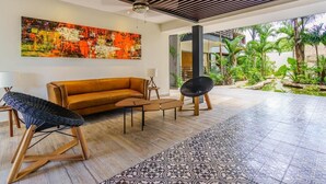 A modern living room with a sofa, a chair, a coffee table, and a large abstract painting on the wall. - Melittas Stylish 2Bed,2Bath-Condo Near Beach - 6 Guests (Playa del Carmen)