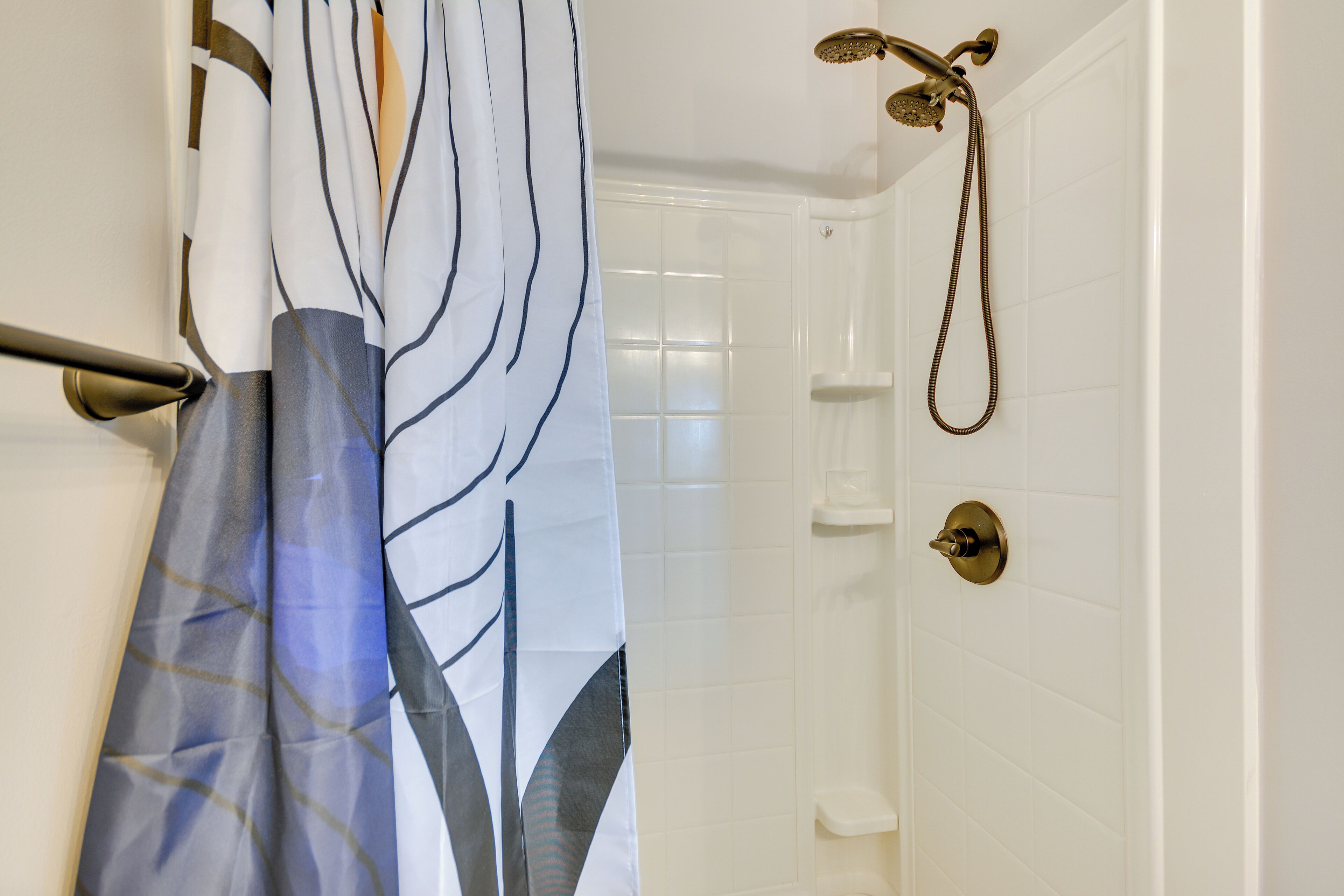 Eine Dusche mit Handbrause und Wandarmatur.
