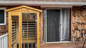 Eine Holzhütte mit einer Schiebetür aus Glas und einer kleinen Veranda.
