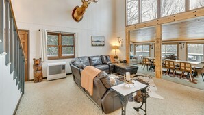 A spacious living room with a large sectional sofa, a mounted deer head, a bear sculpture, and a dining area with wooden chairs and a table. - 6 Mi to Skiing! Hot Tub Hideaway in Seven Devils (Banner Elk)