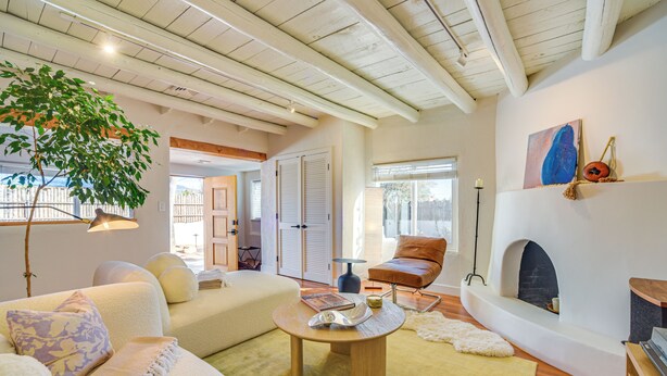 A spacious living room with a fireplace, a large window, and a cozy seating area. - 3 Mi to Downtown - Condo w/ Hot Tub in Santa Fe! (Santa Fe)