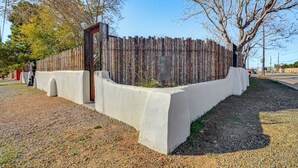 A concrete barrier with a wooden fence behind it, a clear sky, and leafless trees. - 3 Mi to Downtown - Condo w/ Hot Tub in Santa Fe! (Santa Fe)