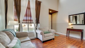 A living room with a sofa, armchair, and a table with a lamp. - Mtns Await: Reno Escape w/ Yard & Pool Table! (Reno)
