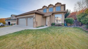 A two-story house with a garage, a well-maintained lawn, and a wooden fence. - Mtns Await: Reno Escape w/ Yard & Pool Table! (Reno)