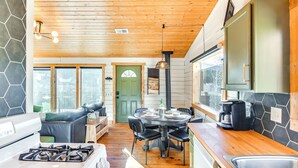 A modern kitchen with a gas stove, a dining area with a round table and chairs, and a large window. - Mtn-view Haven w/ Hot Tub: 9 Mi to Dtwn Bailey (Bailey)