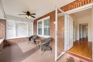 A covered patio with wicker furniture, a ceiling fan, and a brick wall. - Walk to The Grandin Theatre: Roanoke Unit w/ Yard! (Roanoke)