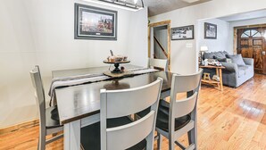 A dining area with a table, chairs, and a chandelier. There is a framed picture on the wall and a door leading to another room. - On 220 Acres: Home w/ Trails in West Liberty! (West Liberty)