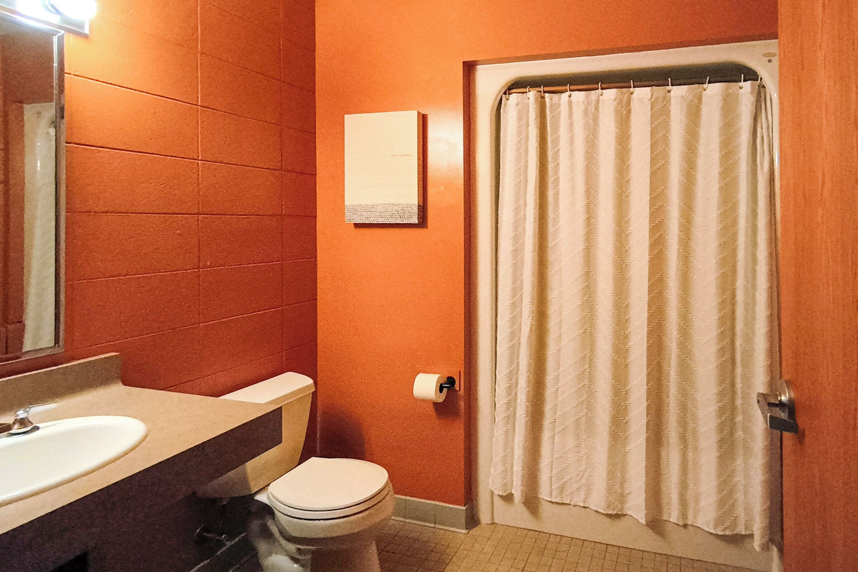 A bathroom with a white sink, toilet, and a shower curtain.