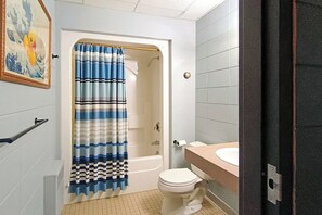 Ein Badezimmer mit Badewanne, Toilette und Duschvorhang.