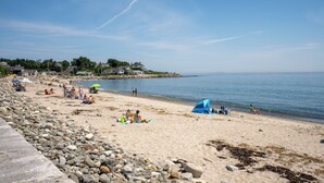 A beach with people relaxing, tents, and houses in the background. - Steps to North Hampton Beach: Cottage w/ Deck! (North Hampton)