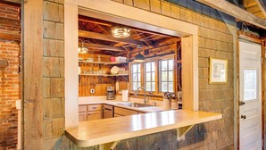 A rustic kitchen with wooden walls, a wooden countertop, and a window overlooking a garden. - Steps to North Hampton Beach: Cottage w/ Deck! (North Hampton)