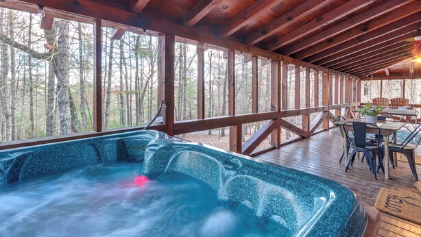 A hot tub area with a wooden deck and a view of the forest. - Ridgetop Cabin in Blue Ridge! Wraparound Porch! (Blue Ridge)