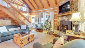 A cozy living room with a wooden ceiling, a fireplace, a Christmas tree, and a television. - Ridgetop Cabin in Blue Ridge! Wraparound Porch! (Blue Ridge)