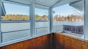 A cabin with large windows overlooking a lake, a wooden deck, and a metal railing. - Lakefront Salem Retreat - Fish, Swim, Kayak & More (Salem)