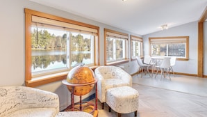 A room with large windows, a globe on a stand, and a table with chairs. - Lakefront Salem Retreat - Fish, Swim, Kayak & More (Salem)