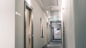 A hallway with doors marked 107-111, a checkered carpet, and a ceiling with recessed lighting. - Boutique Hotel Adelar (Tirana)