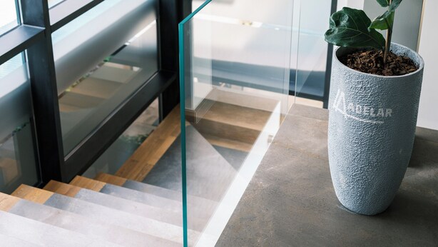 A modern interior with a large window, a staircase, and a potted plant. - Boutique Hotel Adelar (Tirana)