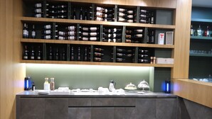 A wine and coffee station with shelves of bottles and a counter with coffee-making equipment. - Boutique Hotel Adelar (Tirana)