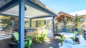 A covered outdoor deck with green Adirondack chairs, a barbecue grill, and a hot tub. - Hot Tub & Mountain Views: 5-Min to Frisco Main St. (Frisco)