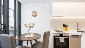 A modern kitchen with a Bosch dishwasher, a sink, and a clock on the wall.