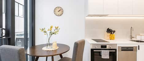 A modern kitchen with a Bosch dishwasher, a sink, and a clock on the wall.