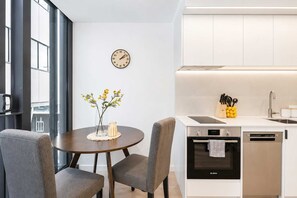 A modern kitchen with a Bosch dishwasher, a sink, and a clock on the wall.