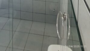 A bathroom with white tiled walls, a glass shower enclosure, and a wooden ceiling. - POUSADA PORTAL DO SOL  (Itacaré)