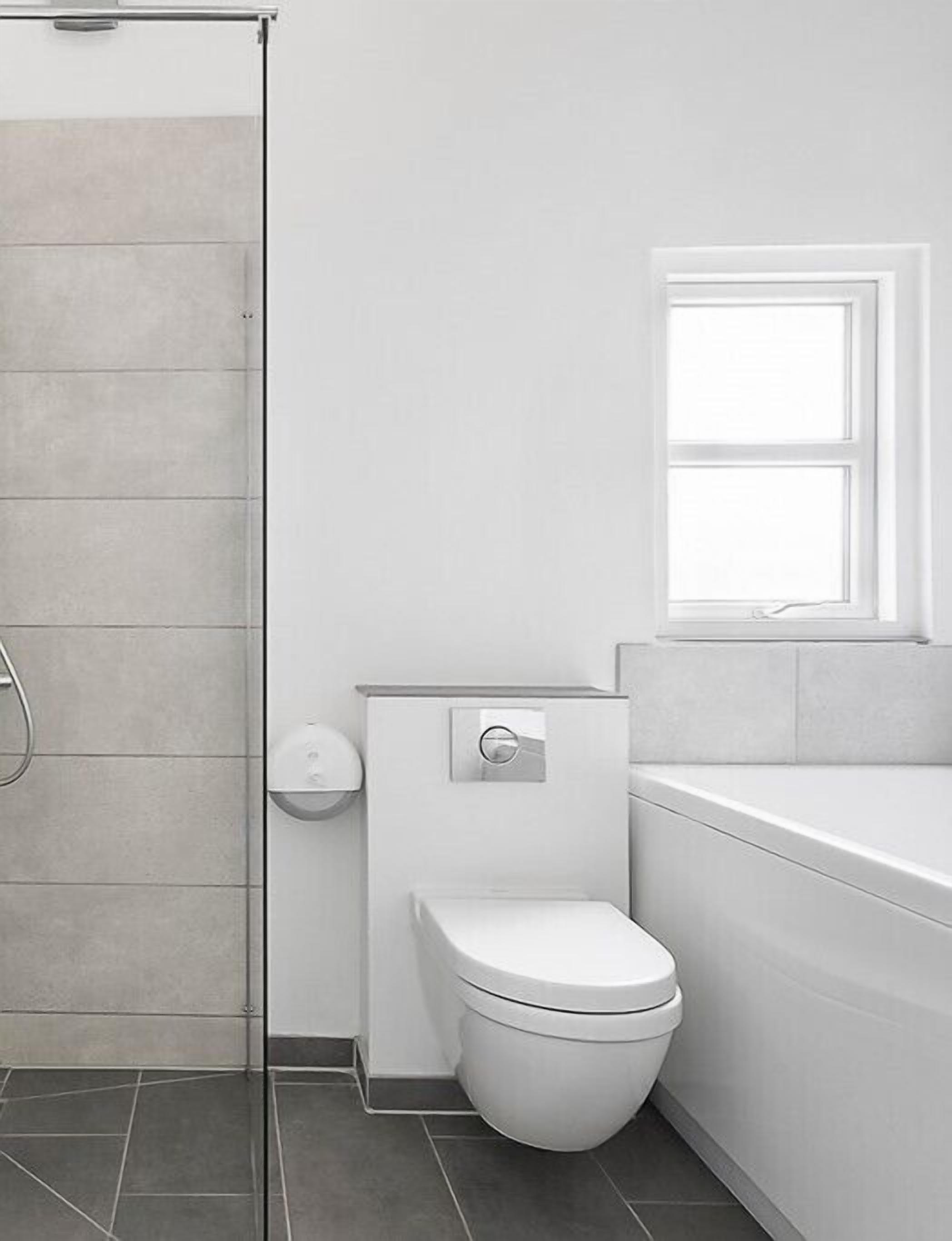 Un baño moderno con inodoro, ducha y bañera.