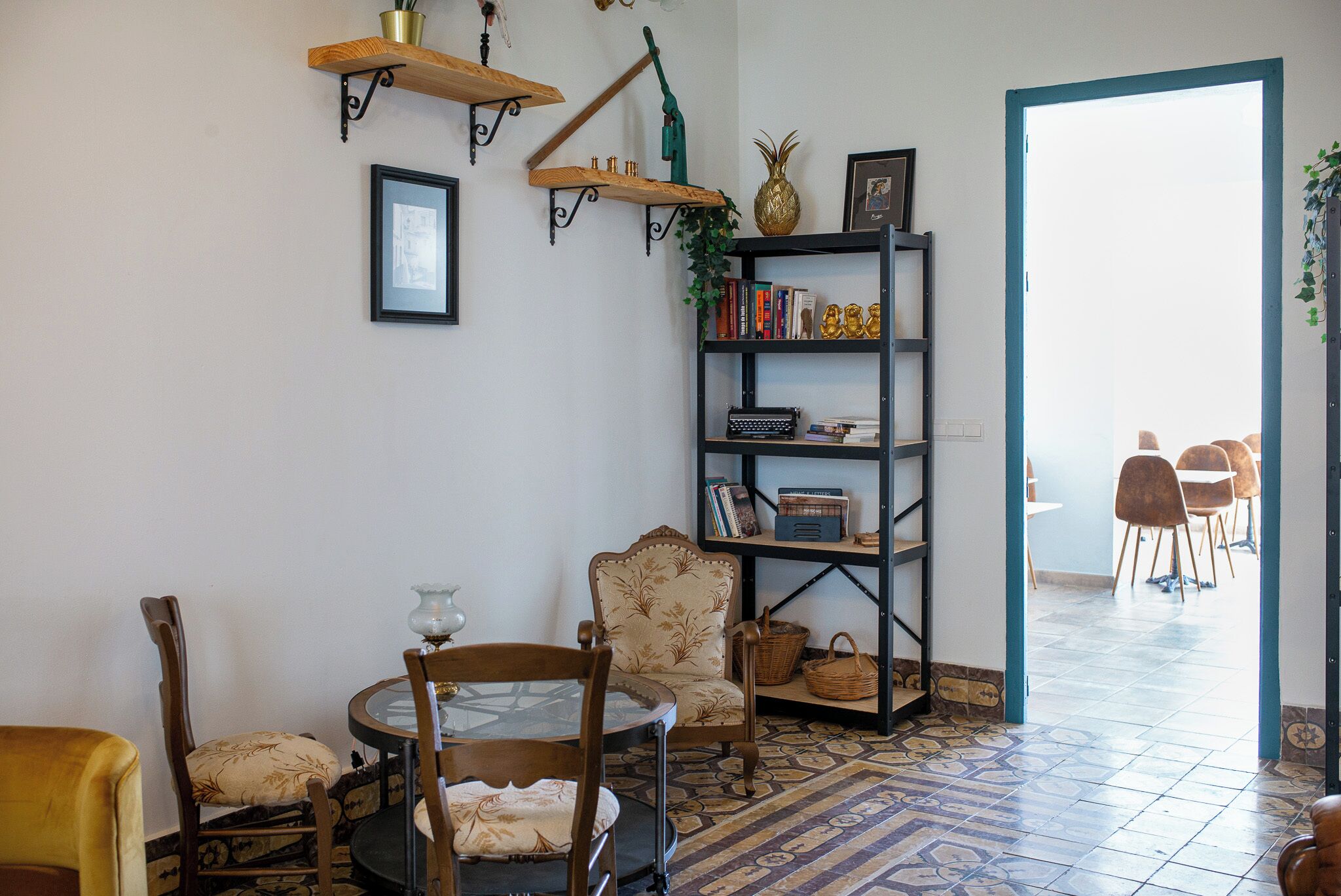 Una sala de estar acogedora con una mesa redonda, una estantería y un suelo con diseño.