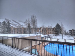 A view of a residential area with a swimming pool, surrounded by buildings and trees.