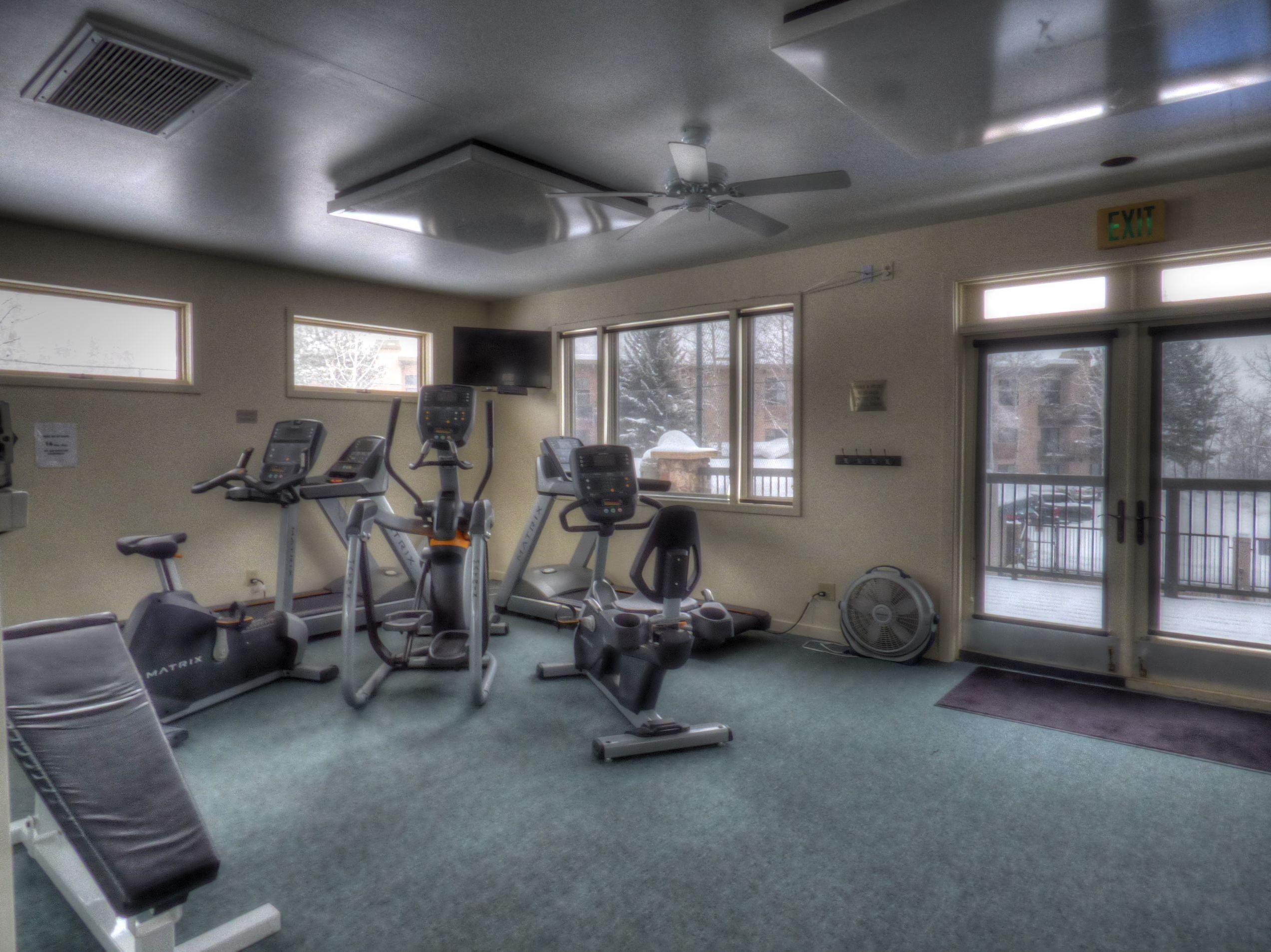 A gym with treadmills, elliptical machines, and a stationary bike.