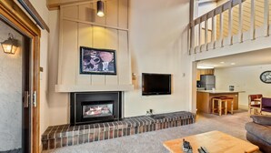 A spacious living area with a fireplace, a television mounted on the wall, and a cozy seating arrangement. - 2 Level Unit w/ Pool Hot Tubs Private Deck (Steamboat Springs)