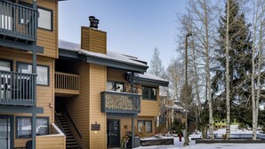 Un edificio a più piani con facciata in legno, balconi e una scala che conduce all'ingresso.